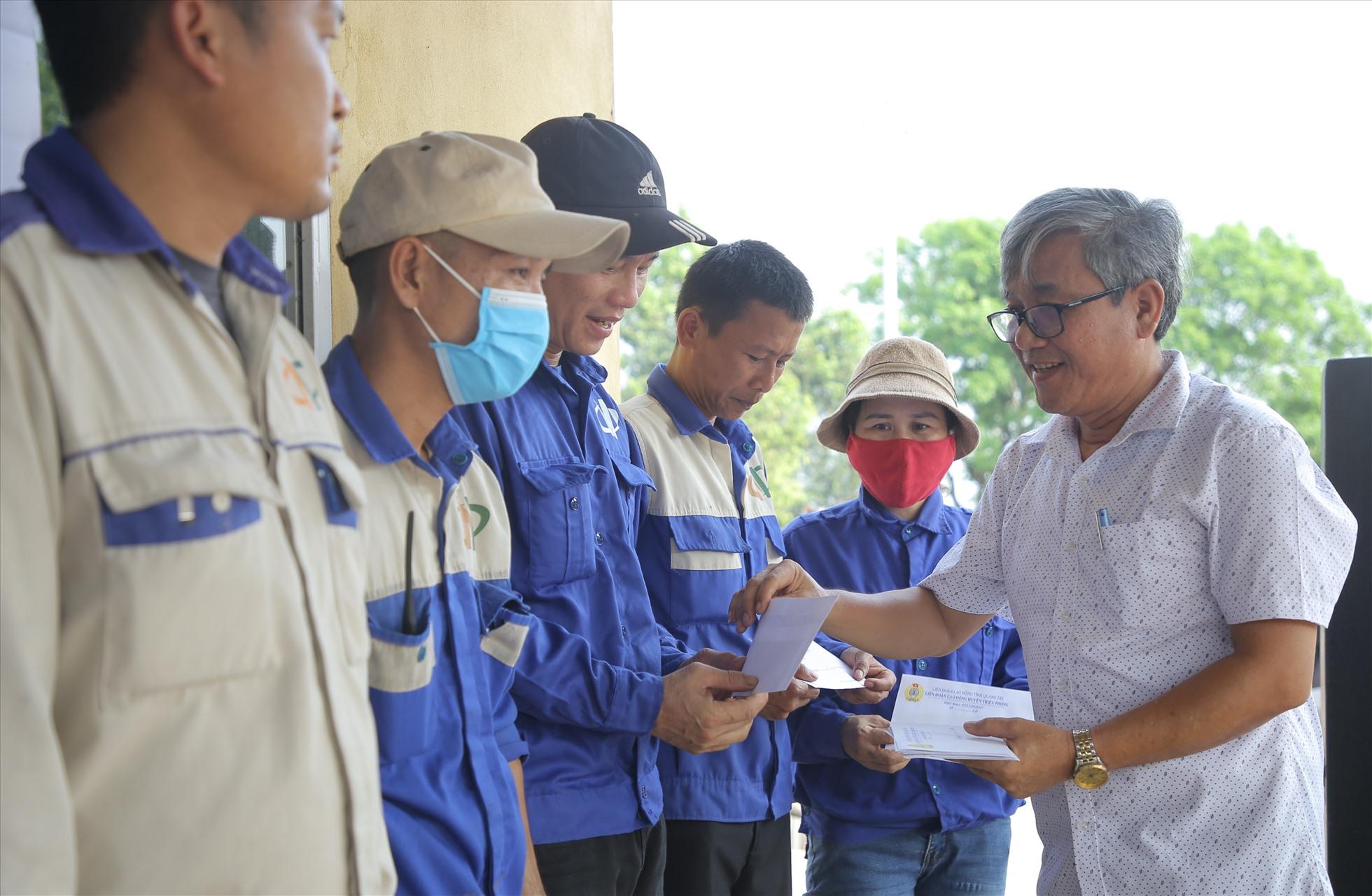 Lãnh đạo UBND huyện Triệu Phong trao tiền hỗ trợ cho công nhân bị cắt giảm giờ làm. Ảnh: Hưng Thơ.