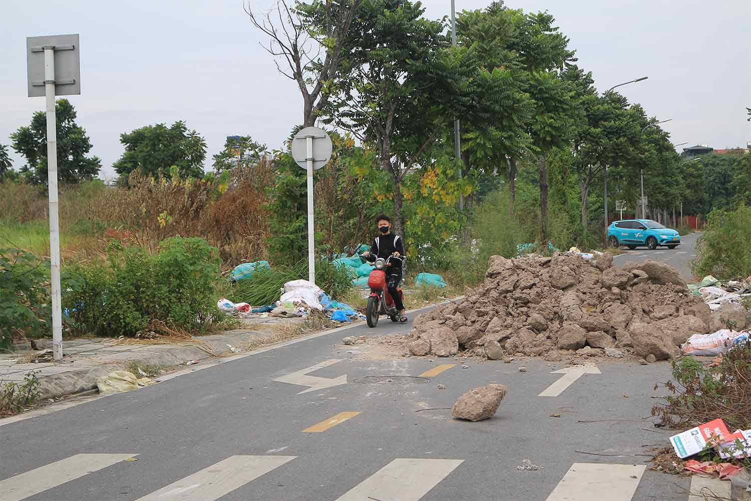 Đống đất bị đổ giữa đường, cản trở việc đi lại của người dân.