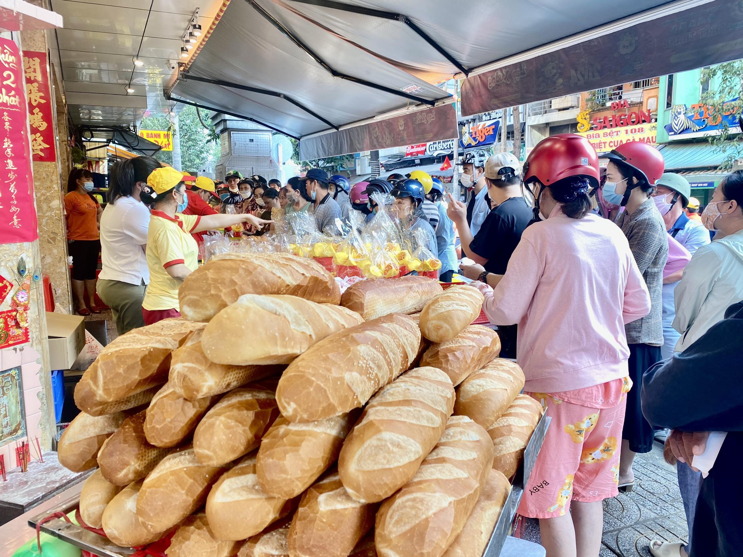 Xếp hàng từ tờ mờ sáng để mua heo quay cúng Thần Tài- Ảnh 1.