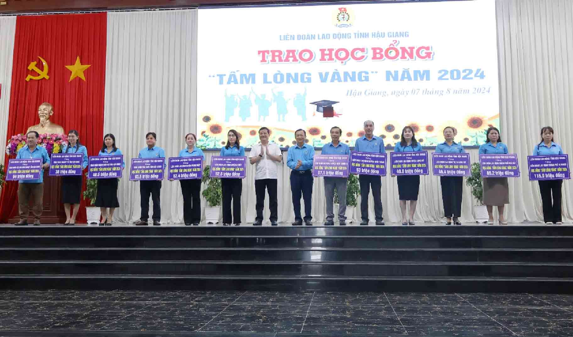 Lãnh đạo tỉnh Hậu Giang trao bảng tượng trưng phân bổ học bổng Tấm lòng vàng đến các đơn vị. Ảnh: LĐLĐ tỉnh Hậu Giang