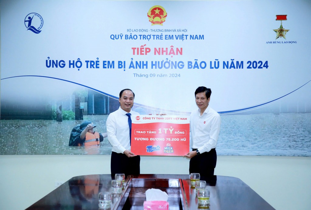 Ông Đinh Tiến Hải - Giám đốc Quỹ BTTEVN tiếp nhận biển tượng trưng sản phẩm Váng sữa và phô mai trị giá 01 tỷ đồng từ ông Bùi Quốc Hùng - Phó Tổng giám đốc Zott Việt Nam trao tặng