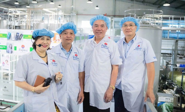 Bà Ngô Thị Thu Thủy hướng dẫn khách tham quan nhà máy sản xuất nước Fujiwa