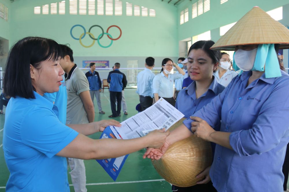 Cán bộ Công đoàn hỗ trợ công nhân điền thông tin trước khi lấy mẫu xét nghiệm tầm soát bệnh. Ảnh: Phương Linh