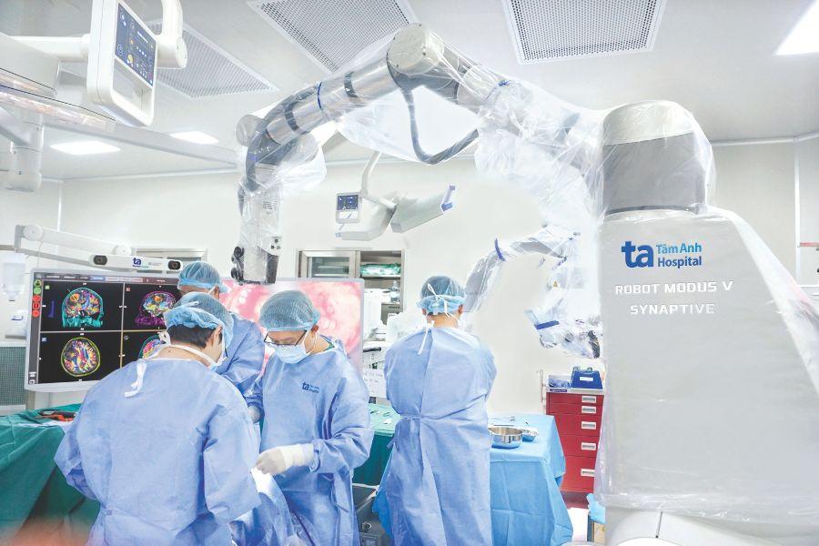 BVĐK Tâm Anh quy tụ đội ngũ chuyên gia đầu ngành thuộc nhiều lĩnh vực. Trong ảnh là ThS.BS.CKII Chu Tấn Sĩ, Trưởng Khoa Phẫu thuật Thần kinh, Trung tâm Khoa học Thần kinh cùng êkip phẫu thuật đang thực hiện loại bỏ u não bằng Robot AI. Ảnh: BVĐK Tâm Anh