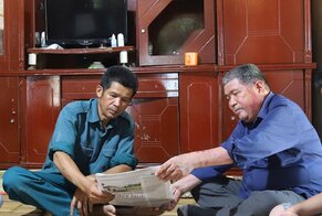 Nghệ nhân Ưu tú Bùi Huy Vọng ( bên phải), người có uy tín ở xóm Bưng Cọi, xã Hương Nhượng (Lạc Sơn) tuyên truyền pháp luật đến người dân trên địa bàn. Ảnh: Bùi Minh