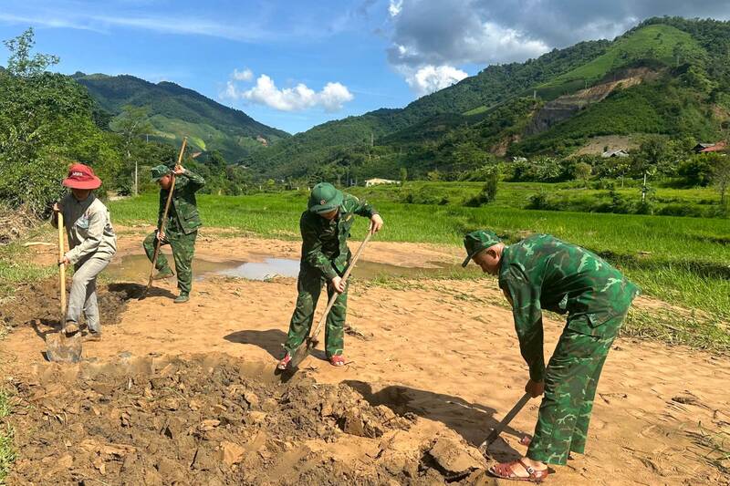 Cán bộ, chiến sĩ Đồn Biên phòng Mường Cai giúp người dân bản Mường Cai, xã Chiềng Khoong khôi phục lại ruộng lúa. Ảnh: Trường Sơn.