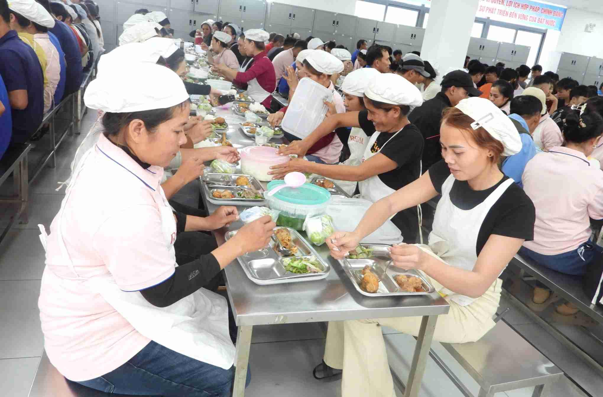 Công nhân lao động ngồi quây quần, vui vẻ dùng bữa trưa. Ảnh: Bảo Trung