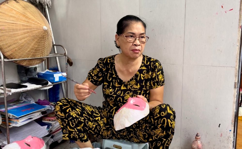 Bà Đặng Hương Lan cẩn thận tô màu thủ công cho từng chiếc mặt nạ. Từ nét cọ đến màu sắc đều được bà thực hiện tỉ mỉ nhằm giữ nguyên phong cách truyền thống. Ảnh: Quỳnh Mai