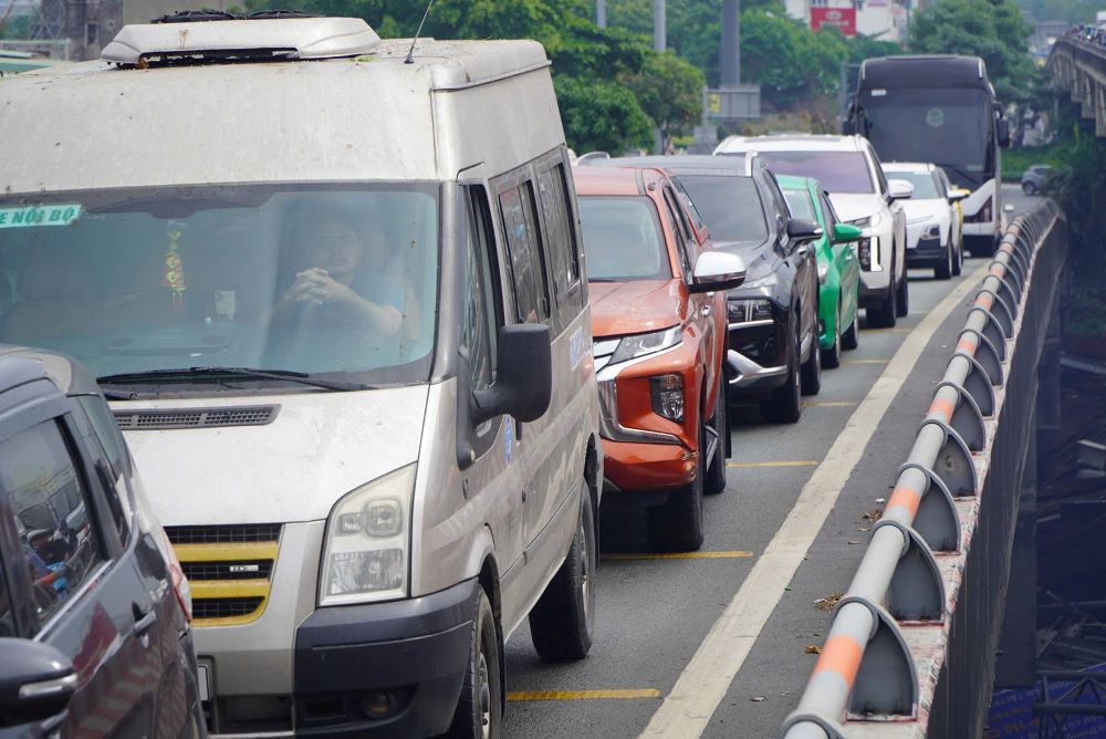 Phương tiện di chuyển chậm, nhiều xe máy lách qua khe hẹp giữa các ô tô để tiếp tục di chuyển.