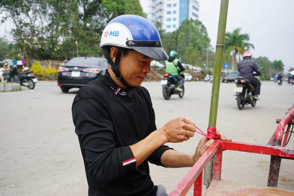 Anh Duẩn (người chở thuê đào quất) chia sẻ về công việc tại chợ hoa trong những ngày áp Tết. Ảnh: Quách Du