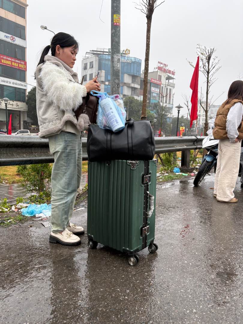 Một người lao động chờ bắt xe khách. Ảnh: Bảo Hân