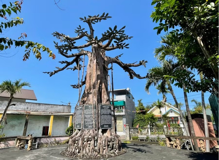 Cây đa bằng bê tông biểu tượng nguồn cội và hệ thống 7 bia đá khắc chữ đa ngữ tại Di tích lịch sử Nước Mặn. Ảnh: TL 1nm2.jpg