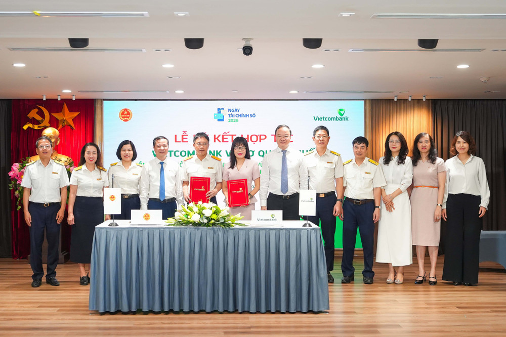Ông Mai Sơn - Phó Cục Trưởng Cục Thuế (thứ 5, từ trái sang) và bà Đoàn Hồng Nhung - Thành viên Ban điều hành, Giám đốc Khối Bán lẻ Vietcombank (thứ 6, từ trái sang) thực hiện nghi thức ký kết và trao biên bản Thỏa thuận Hợp tác giữa Cục Thuế và Vietcombank dưới sự chứng kiến của đại diện lãnh đạo hai đơn vị. 20260603-ndt-vcb-kyket-thue-anh-3.jpg