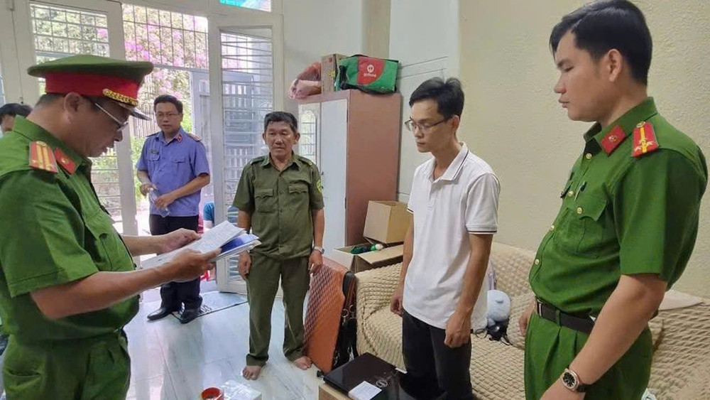 Đối tượng Trần Minh Duy nghe cơ quan điều tra đọc lệnh bắt giam (Ảnh: CACC)
