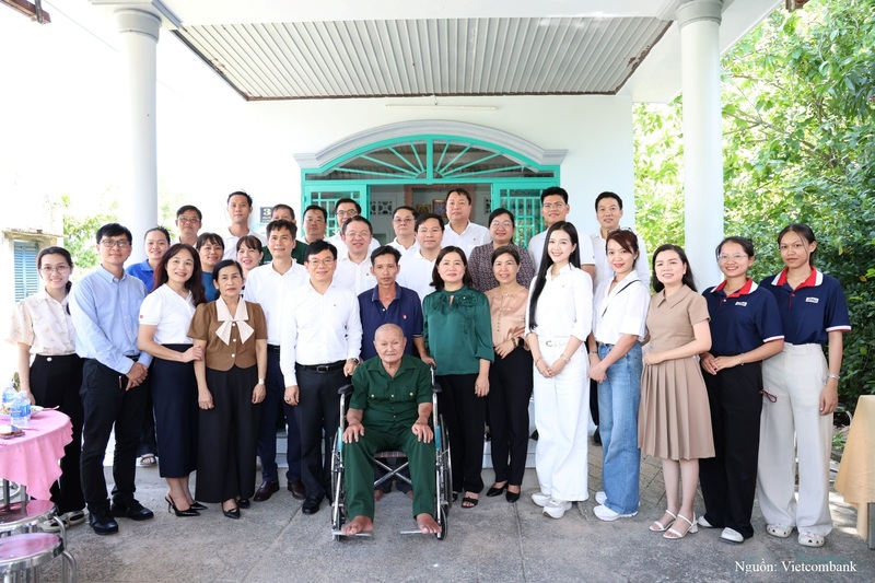 Đại diện Vietcombank, Báo Tiền Phong, chính quyền địa phương, các gia đình cựu chiến binh và người dân chụp ảnh lưu niệm trước ngôi nhà mới của cựu chiến binh Châu Văn Đực tại xã Củ Chi.