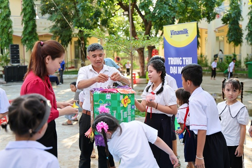 Các em nhỏ hào hứng tham gia trò chơi cùng nhân viên Vinamilk trong ngày hội trăng rằm (Ảnh: Nguyễn Hoàng). Các em nhỏ cùng thầy cô tham gia thiết kế đồ chơi và chuẩn bị mâm cỗ Trung thu tại ngày hội (Ảnh: Nguyễn Hoàng).