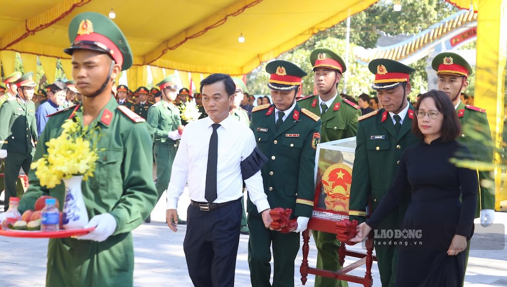 Lãnh đạo tỉnh Quảng Trị cùng di chuyển hài cốt liệt sĩ đến nơi an táng. Ảnh: Hưng Thơ